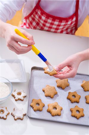 Girl decorating Christmas biscuits Stock Photo - Premium Royalty-Free, Code: 659-03533132