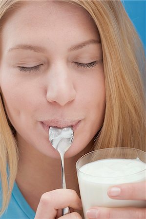 simsearch:659-06184002,k - Jeune femme mangeant yaourt nature Photographie de stock - Premium Libres de Droits, Code: 659-03533215
