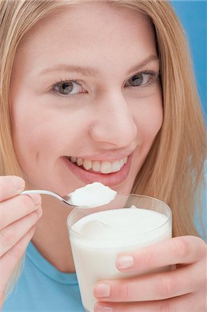 Young woman eating natural yoghurt Stock Photo - Premium Royalty-Free, Code: 659-03533216