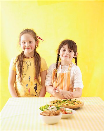 Two girls standing by kitchen table Stock Photo - Premium Royalty-Free, Code: 659-03533246