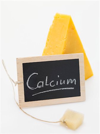 queso cheddar - Slate board with the word Calcium in front of piece of Cheddar Foto de stock - Sin royalties Premium, Código: 659-03533257