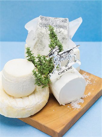 Various goat's cheeses on chopping board Stock Photo - Premium Royalty-Free, Code: 659-03533262