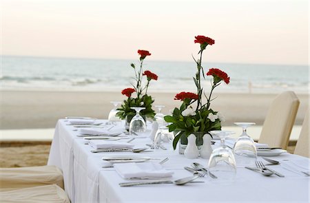 Laid table with red carnations on beach Stock Photo - Premium Royalty-Free, Code: 659-03533347