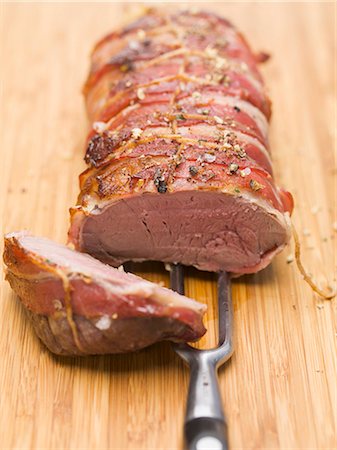 Bacon-wrapped leg of venison Foto de stock - Sin royalties Premium, Código: 659-03533389