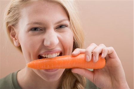 simsearch:659-06151776,k - Woman biting a fresh carrot Foto de stock - Sin royalties Premium, Código: 659-03533530