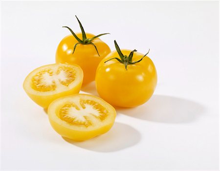 Whole and halved yellow tomatoes Stock Photo - Premium Royalty-Free, Code: 659-03533565