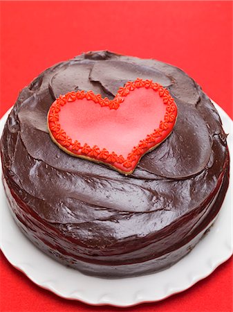 Chocolate cake with red heart-shaped biscuit Foto de stock - Sin royalties Premium, Código: 659-03533597