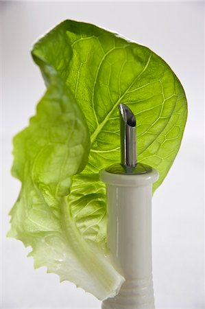 A lettuce leaf with an oil bottle Stock Photo - Premium Royalty-Free, Code: 659-03533829