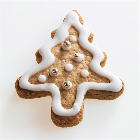 dolci natalizi - Christmas tree shaped biscuit with white icing and silver dragees Fotografie stock - Premium Royalty-Free, Codice: 659-03533853