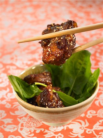 Sweet and sour pork with sesame seeds and spinach shoots Stock Photo - Premium Royalty-Free, Code: 652-05806907