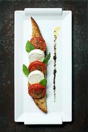 Grilled tomatoes,fresh goat's cheese and herbs on toast Stock Photo - Premium Royalty-Free, Code: 652-05807162