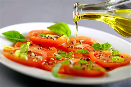 Verser l'huile d'olive sur une salade de tomates et basilic Photographie de stock - Premium Libres de Droits, Code: 652-05808176