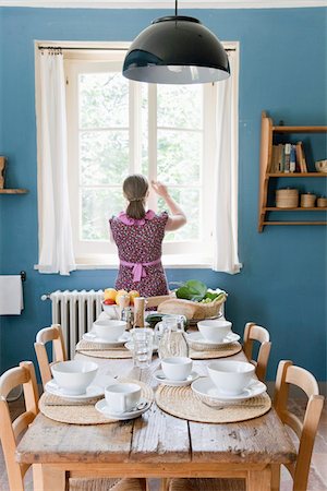 Lunch table in the kitchen and a woman closing the window Foto de stock - Sin royalties Premium, Código: 652-05808583