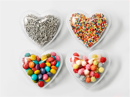 Transparent hearts filled with sugar vermicellis and multicolored sugar balls for decorating cakes Stock Photo - Premium Royalty-Free, Code: 652-05808837