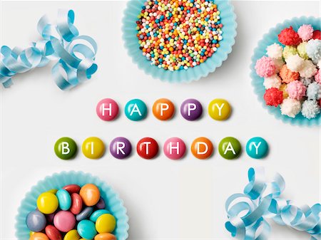 Happy Birthday written on Smarties and paper cup full of sugar balls for decorating cakes Stock Photo - Premium Royalty-Free, Code: 652-05808848