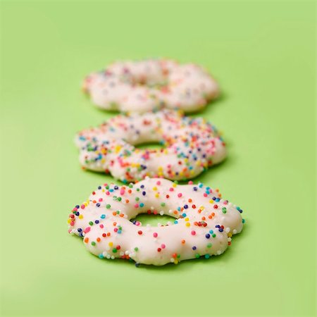 Zeile von Cookies in Puderzucker überzogen und verziert mit Multicolores Zucker-Bälle Stockbilder - Premium RF Lizenzfrei, Bildnummer: 652-05808868