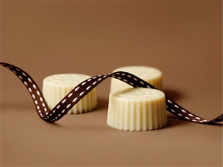 simsearch:652-05808884,k - White chocolates and ribbon Stock Photo - Premium Royalty-Free, Code: 652-05808874