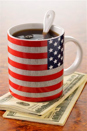 Cup of coffee in a mug with the American flag on it and dollar bills Stock Photo - Premium Royalty-Free, Code: 652-05808986