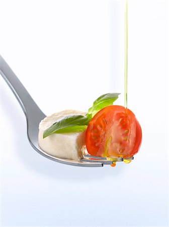 Tomato, mozzarella, basil and olive oil on a fork Stock Photo - Premium Royalty-Free, Code: 652-06818660