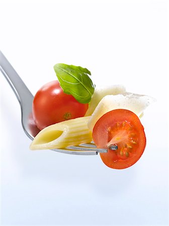 short pasta - Penne, tomato, parmesan and basil on a fork Stock Photo - Premium Royalty-Free, Code: 652-06818661