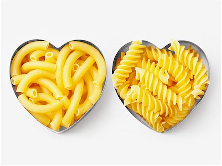 pasta overhead - Assorted pasta in heart-shaped biscuit cutters Stock Photo - Premium Royalty-Free, Code: 652-06818797