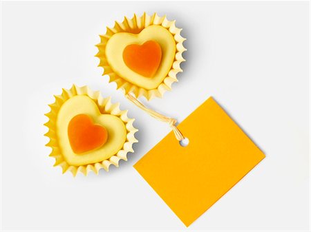 simsearch:652-03805162,k - Small orange candies in heart-shaped paper cups and a label Photographie de stock - Premium Libres de Droits, Code: 652-06818819