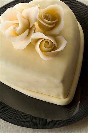 simsearch:652-06818932,k - Heart-shaped cake with frosting and flowers Foto de stock - Royalty Free Premium, Número: 652-06818924