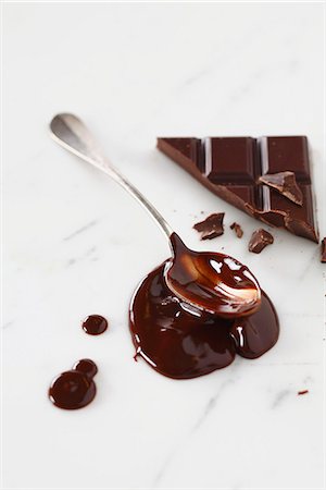 Spreading the melted chocolate onto a marble surface with the back of a spoon Foto de stock - Royalty Free Premium, Número: 652-06819025