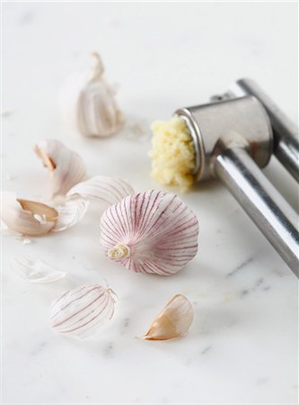 Crushing garlic with a garlic crusher Foto de stock - Sin royalties Premium, Código: 652-06819031