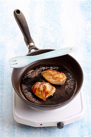 fornellino elettrico - Glazing pieces of chicken in a frying pan Fotografie stock - Premium Royalty-Free, Codice: 652-07656110