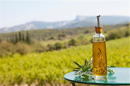 Bottle of olive oil on a table outdoors Stock Photo - Premium Royalty-Free, Code: 652-07656258