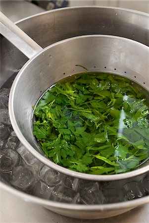 simsearch:652-07656398,k - Plunging freshly boiled herbs in a pan of iced water Photographie de stock - Premium Libres de Droits, Code: 652-07656400