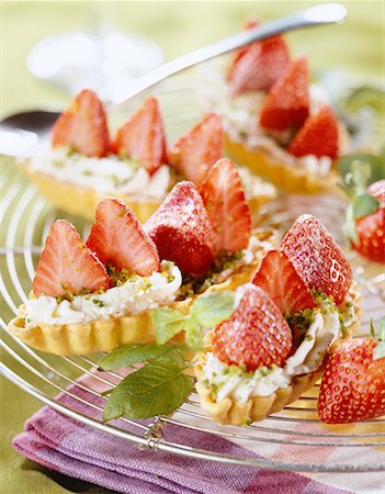 strawberry tartlet - pastry boat filled with strawberries,whipped cream and pistchios Stock Photo - Premium Royalty-Free, Code: 652-01669655