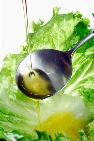 scorrere - Pouring a drop of olive oil onto a lettuce leaf Fotografie stock - Premium Royalty-Free, Codice: 652-02222077