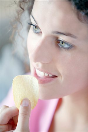 Woman eating a chip Stock Photo - Premium Royalty-Free, Code: 652-03634270