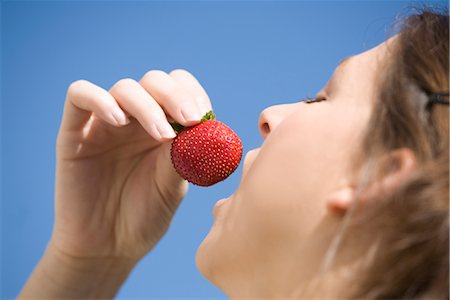 simsearch:652-03801651,k - Woman eating a strawberry Foto de stock - Sin royalties Premium, Código: 652-03634424