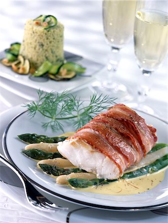 Cod wrapped in bacon with saffron cream sauce and a semolina timbale Foto de stock - Sin royalties Premium, Código: 652-03634599