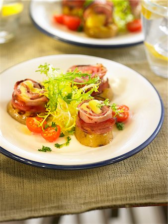 Rolled bacon and cheese on sliced potatoes,lettuce and tomato salad Stock Photo - Premium Royalty-Free, Code: 652-03804237