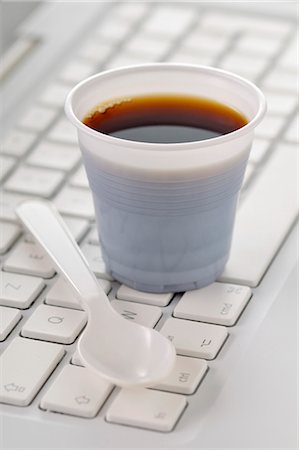Gobelet de café sur le clavier d'un ordinateur Photographie de stock - Premium Libres de Droits, Code: 652-03804518