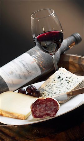 round slice - Plate of cheese and dried sausage,bottle and glass of red wine Stock Photo - Premium Royalty-Free, Code: 652-03804616