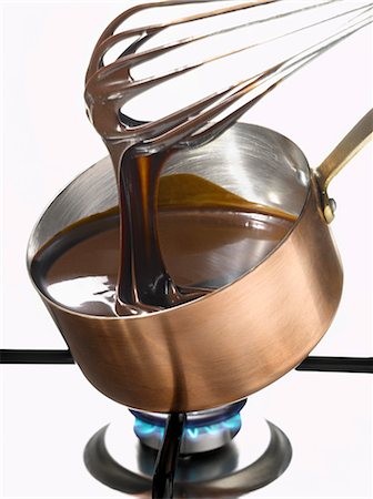 Whipping melted dark chocolate in a copper saucepan Stock Photo - Premium Royalty-Free, Code: 652-03802241