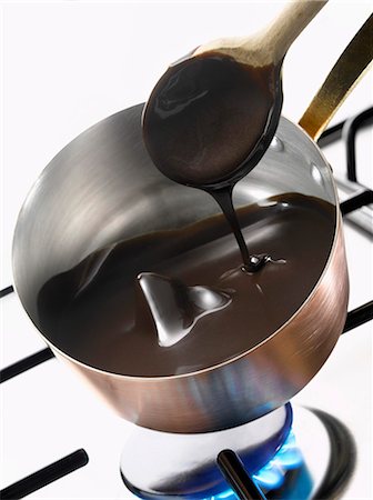 pequeno fogão portátil - Melting dark chocolate in a copper saucepan Foto de stock - Royalty Free Premium, Número: 652-03802242