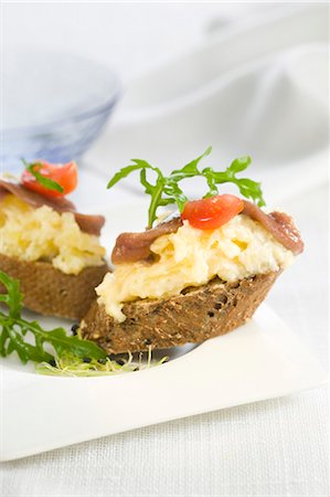 simsearch:652-03802601,k - Crushed potatoes and anchovies on a bite-size slice of bread Stock Photo - Premium Royalty-Free, Code: 652-03802587