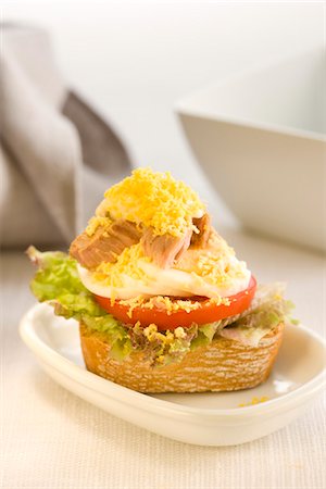 simsearch:652-03802583,k - Tuna,tomato and lettuce on a bite-size slice of bread Foto de stock - Sin royalties Premium, Código: 652-03802602
