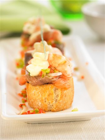 Seafood and anchovies on a bite-size slice of bread Foto de stock - Sin royalties Premium, Código: 652-03802614