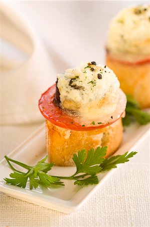 Blood sausage and goat's cheese on a bite-size slice of bread Stock Photo - Premium Royalty-Free, Code: 652-03802624