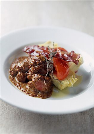 Veal kidneys in tradional mustard sauce,pan-fried tomatoes,artichokes and bacon Stock Photo - Premium Royalty-Free, Code: 652-03803123