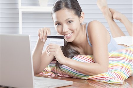 Young woman enjoying online shopping Stock Photo - Premium Royalty-Free, Code: 669-05854490