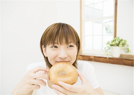 people eating bagels - A woman eating bagel Stock Photo - Premium Royalty-Free, Code: 669-02642257