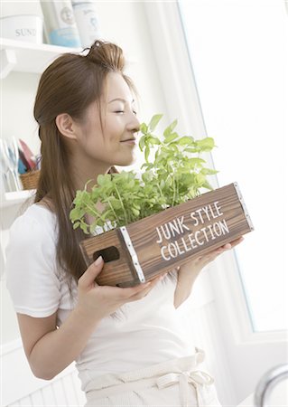Woman holding a planter of herbs Stock Photo - Premium Royalty-Free, Code: 669-03708188